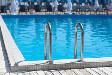 Photo of Modern swimming pool with step ladder outdoors