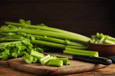 Photo of Cut fresh green celery on wooden board