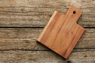 Photo of One new cutting board on old wooden table, top view. Space for text