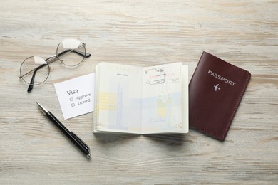 Moldova, Ceadir-Lunga - June 13, 2022: Passports with visa stamps, pen and glasses on wooden table, flat lay