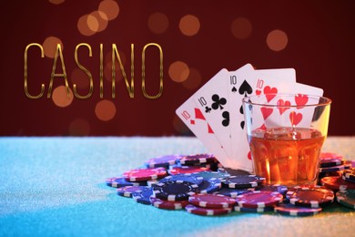 Illustration of Word Casino, chips, playing cards and glass of alcohol on table against red background with blurred lights. Bokeh effect