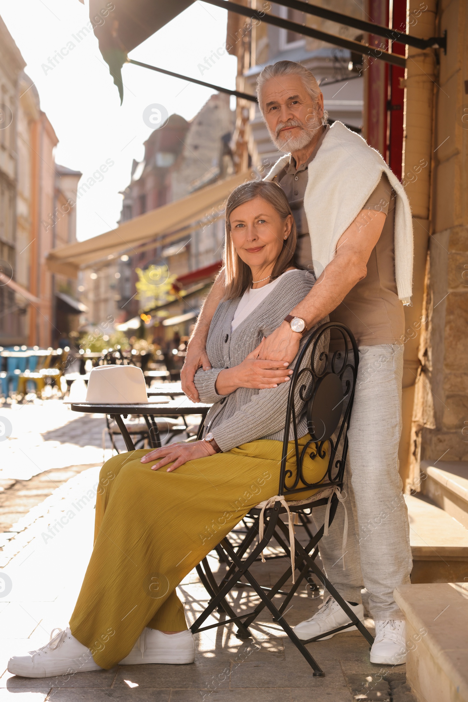 Photo of Affectionate senior couple sitting in outdoor cafe