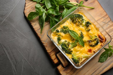 Photo of Tasty broccoli casserole in baking dish on grey table, top view