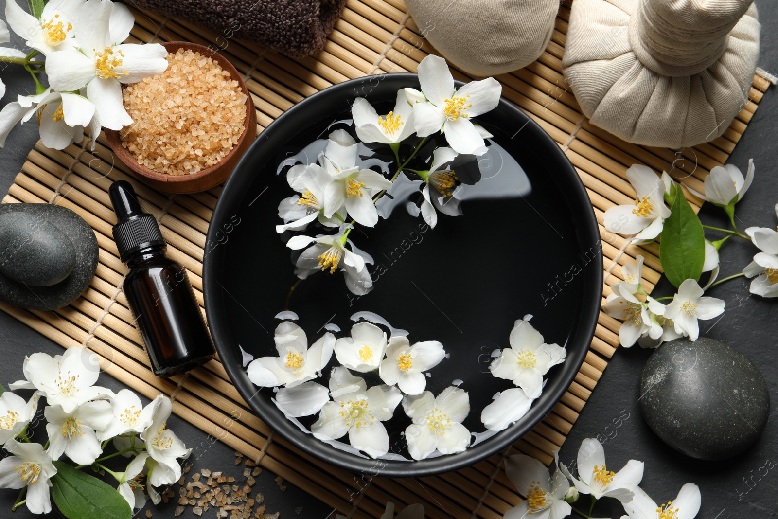 Photo of Beautiful spa composition with jasmine essential oil and fresh flowers on table, flat lay