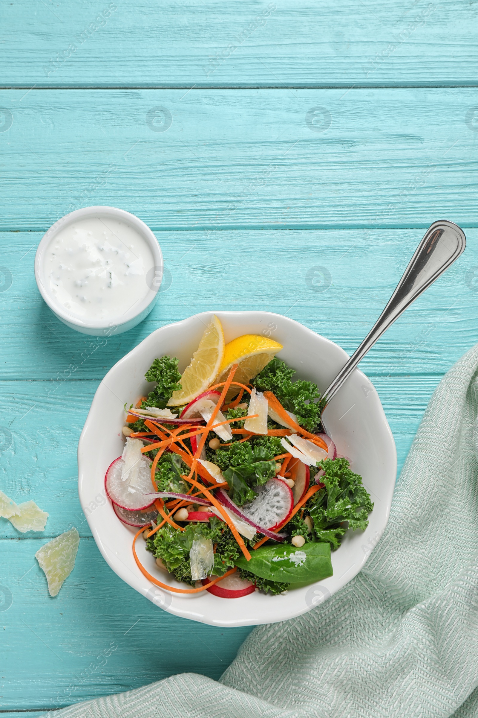 Photo of Tasty fresh kale salad on light blue wooden table, flat lay