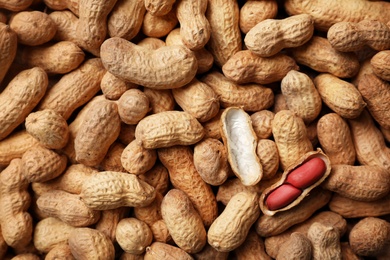 Photo of Dry peanuts in shell as background, top view. Healthy snack