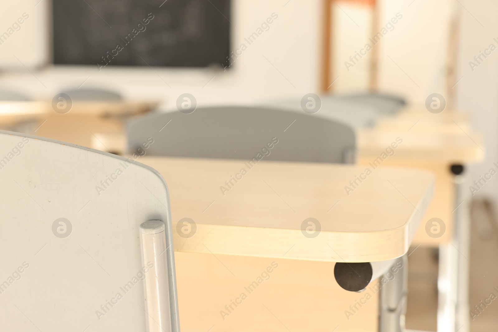 Photo of Empty school classroom with desks and chairs