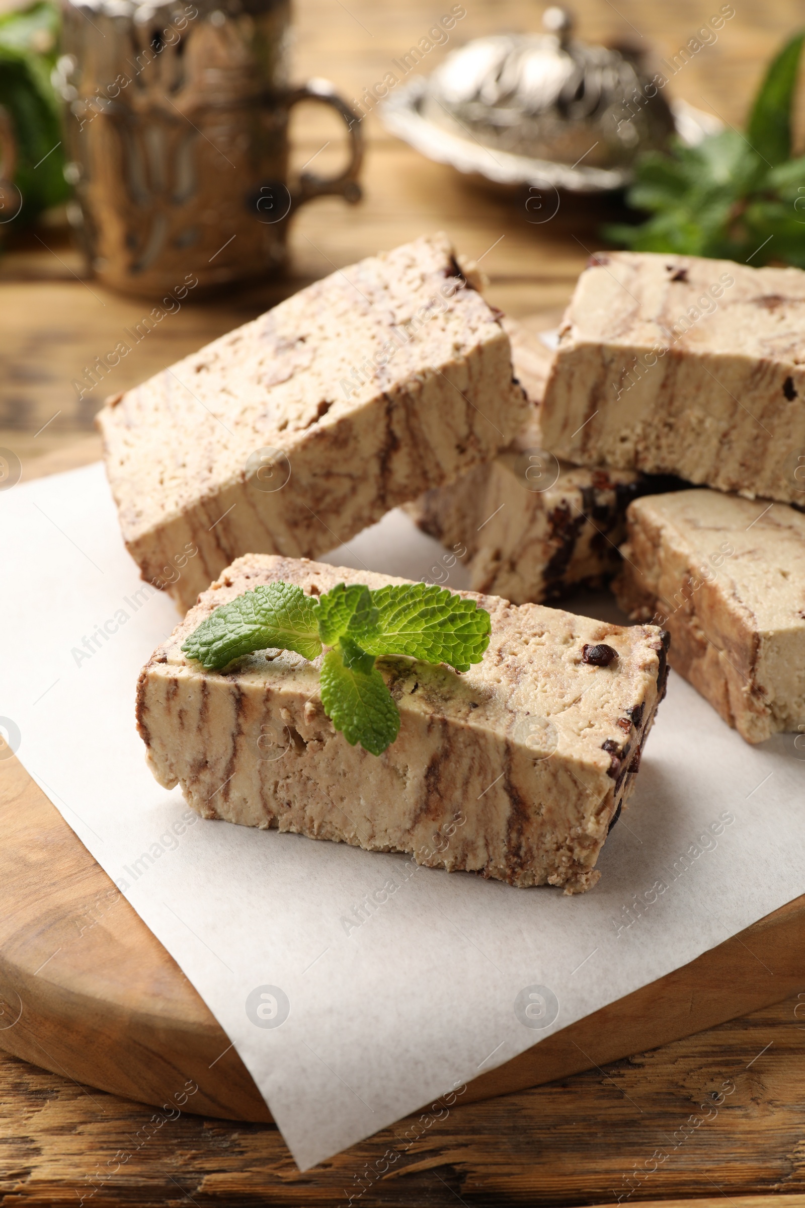 Photo of Tasty chocolate halva with mint on wooden table