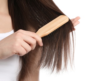 Woman with hair brush on white background, closeup