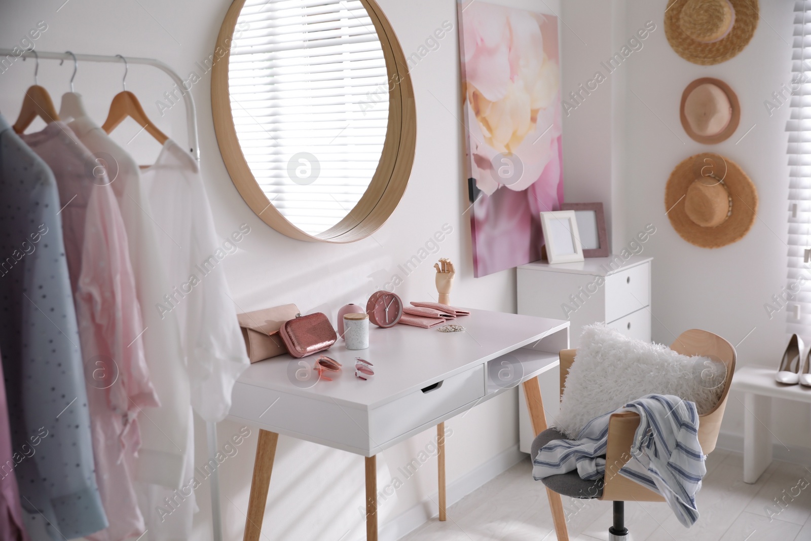 Photo of Dressing room interior with stylish makeup table, clothes and accessories