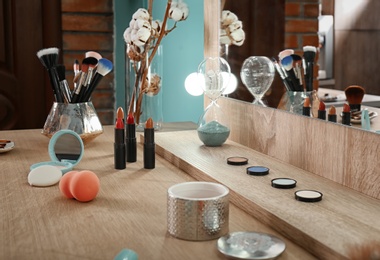 Photo of Decorative cosmetics and tools on dressing table in makeup room, closeup