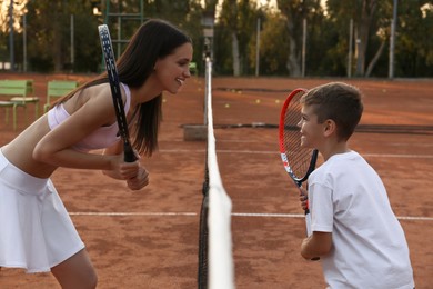 Photo of Mother with her son on tennis court