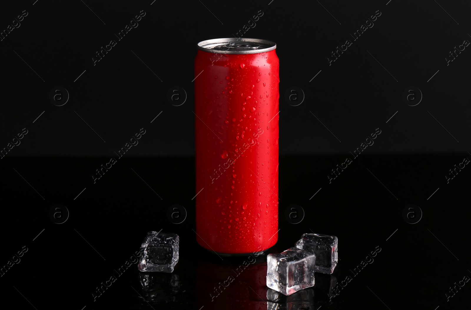Photo of Energy drink in wet can and ice cubes on black background