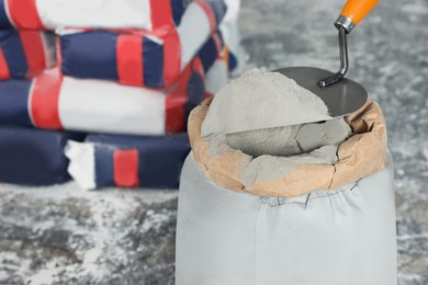 Cement powder and trowel put in bag on stone floor, closeup. Space for text