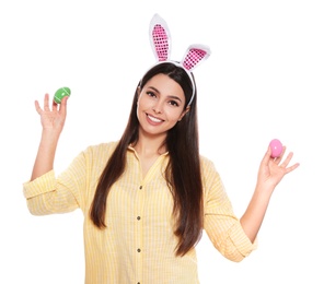 Photo of Beautiful woman in bunny ears headband holding Easter eggs on white background
