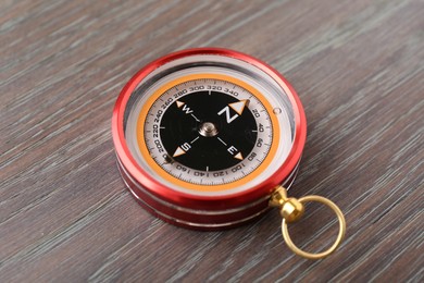 One compass on wooden table, closeup. Navigation equipment