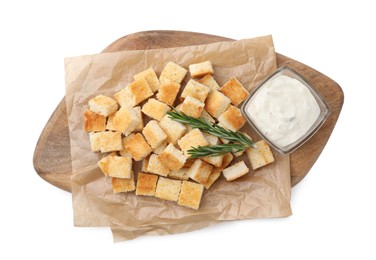 Delicious crispy croutons with rosemary and sauce on white background, top view