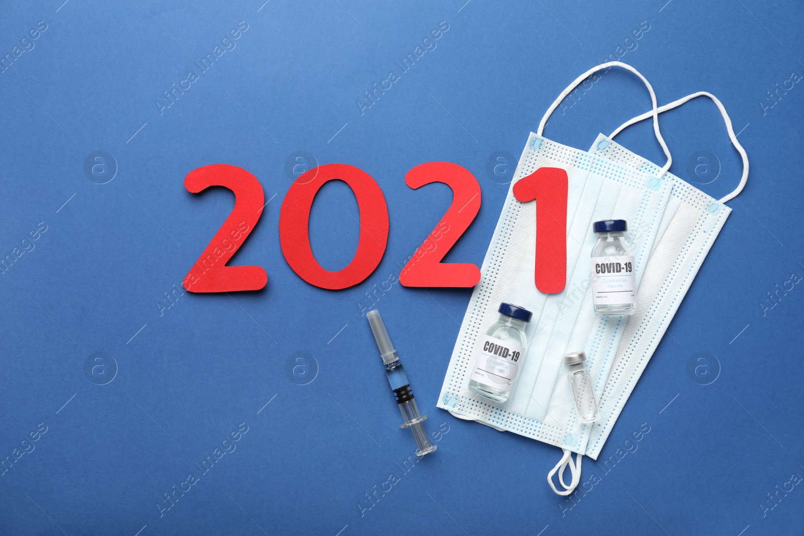 Photo of Flat lay composition with coronavirus vaccine and number 2021 on blue background