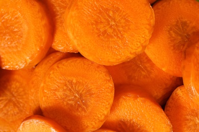 Photo of Slices of fresh ripe carrots as background, top view