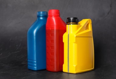 Photo of Motor oil in different canisters on black background