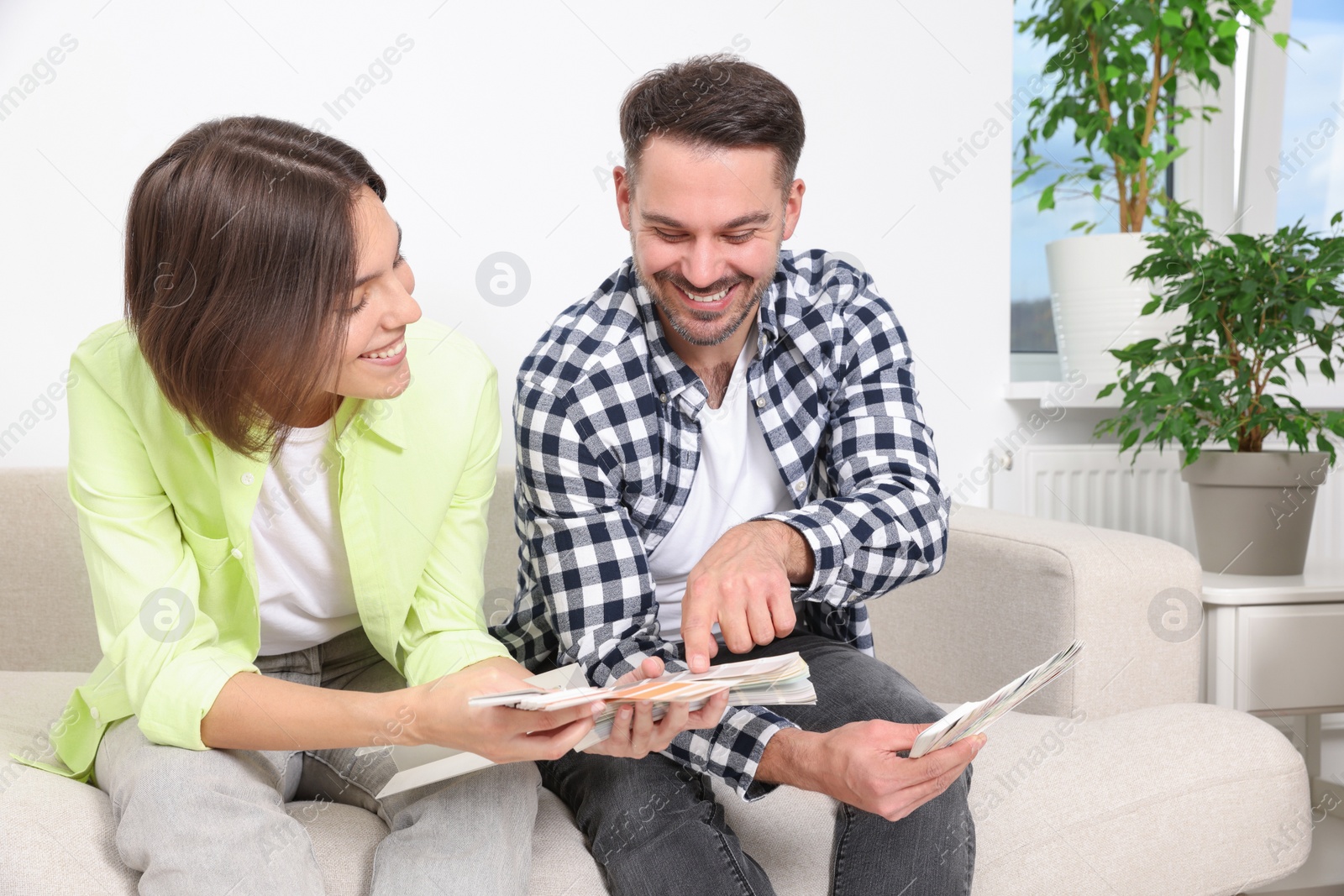 Photo of Happy couple choosing colors in new apartment. Moving day