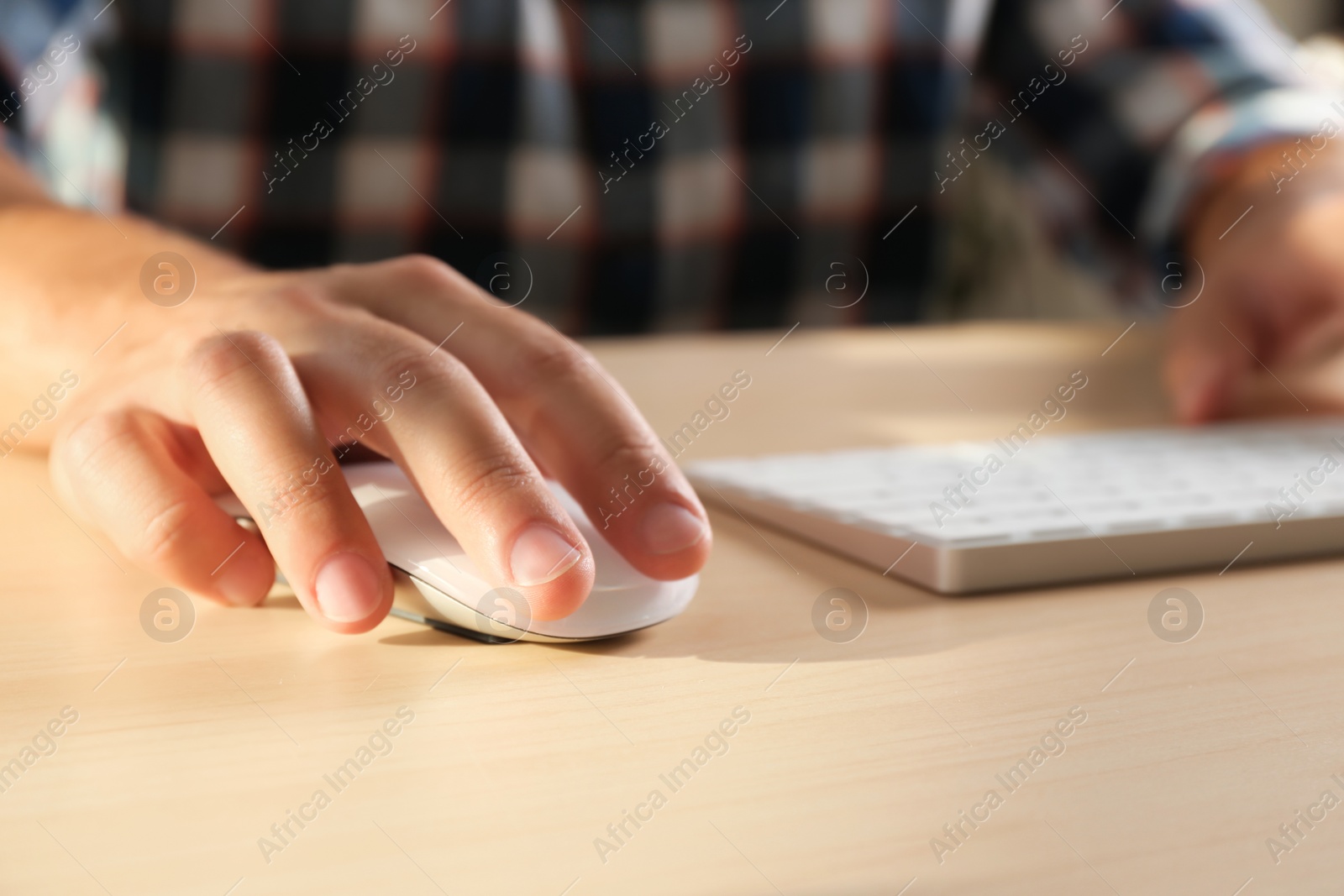 Photo of Man using computer mouse and keyboard at table, closeup