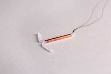 T-shaped intrauterine birth control device on light background