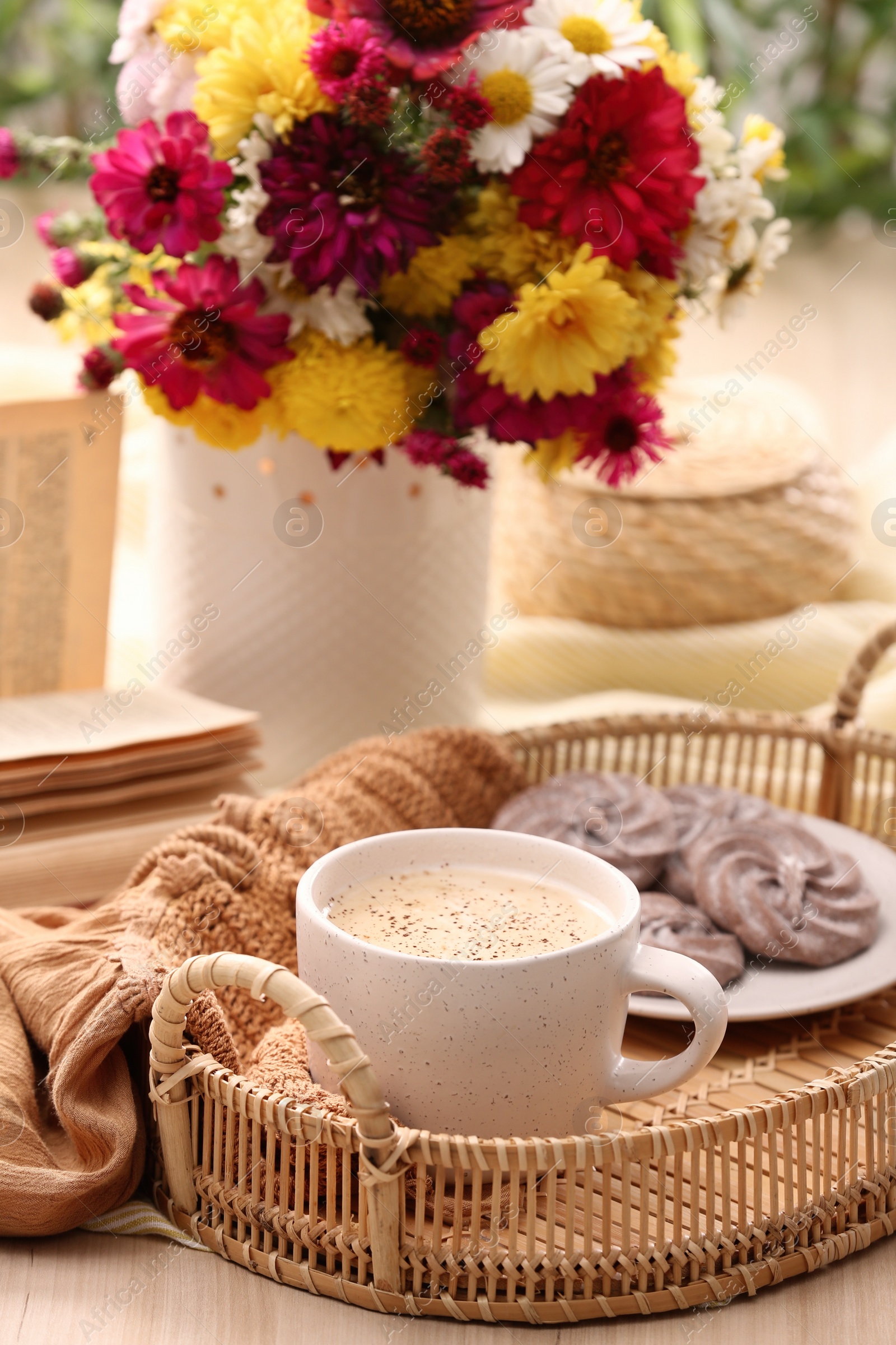 Photo of Cup of hot coffee, delicious cookies and beautiful bouquet on wooden table