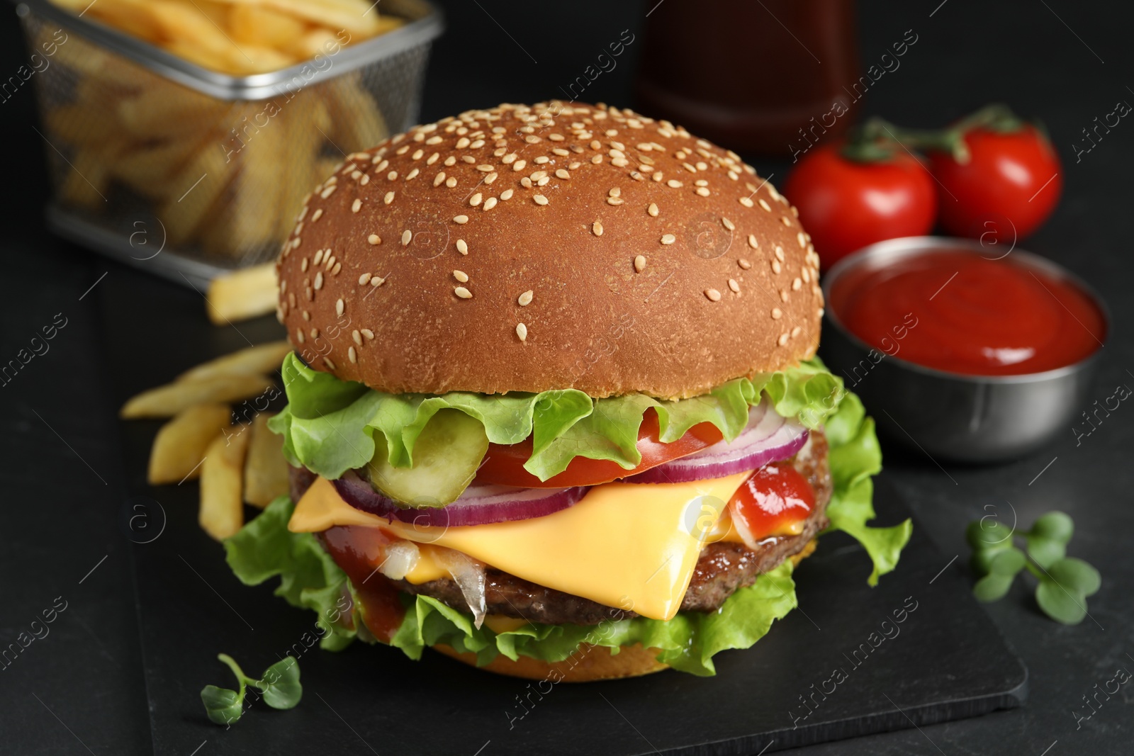 Photo of Delicious burger with beef patty on dark table, closeup