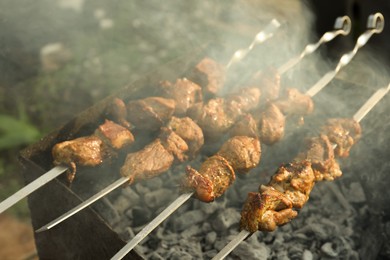 Cooking delicious meat on metal brazier outdoors