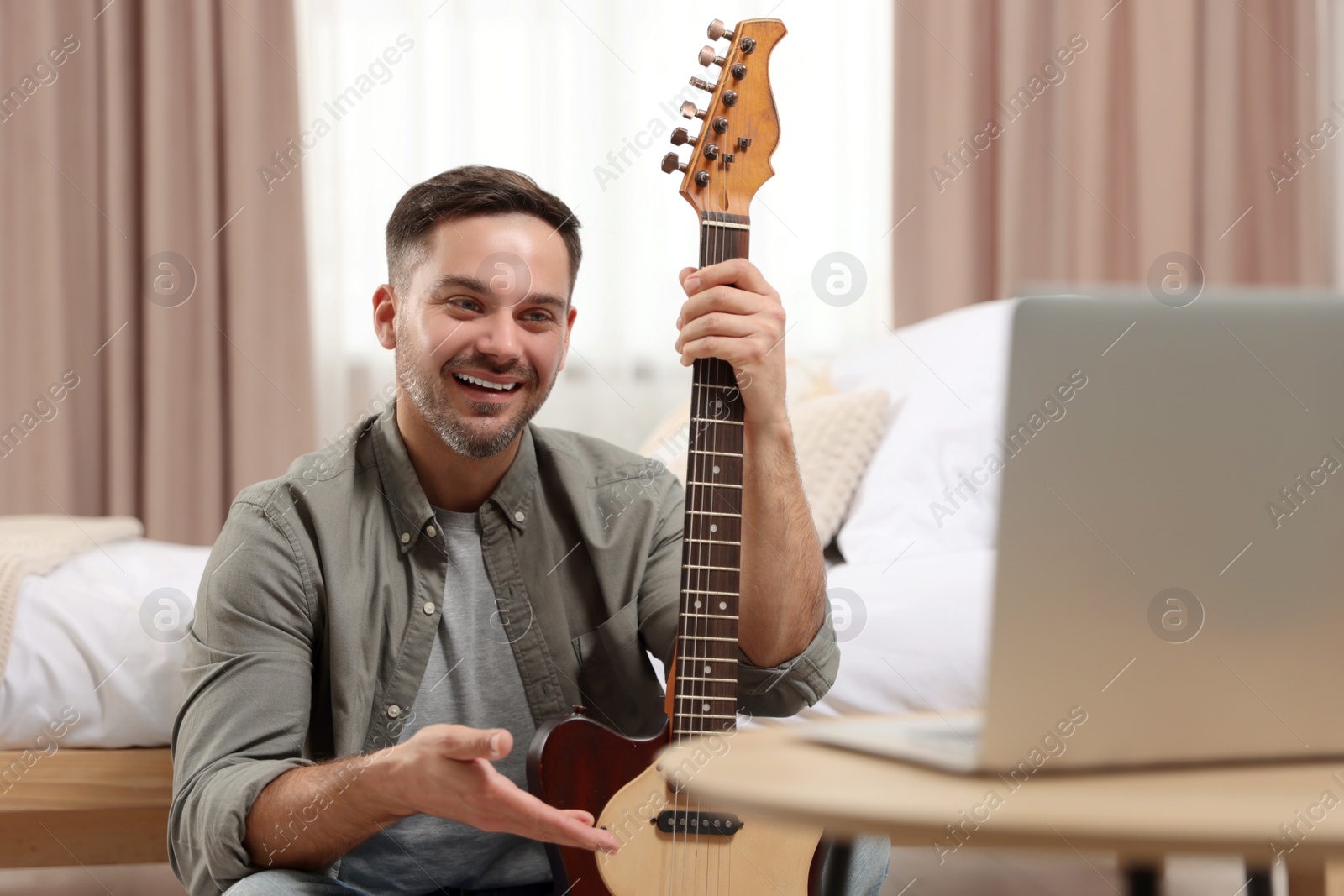 Photo of Music teacher talking with students while conducting online lesson at home. Time for hobby