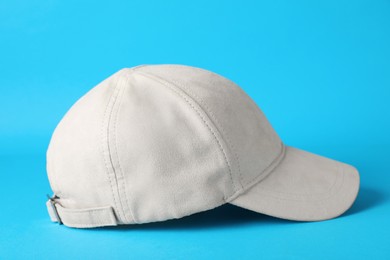 Photo of Stylish beige baseball cap on light blue background