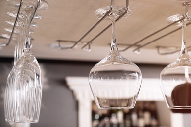 Photo of Set of empty clean glasses on bar racks