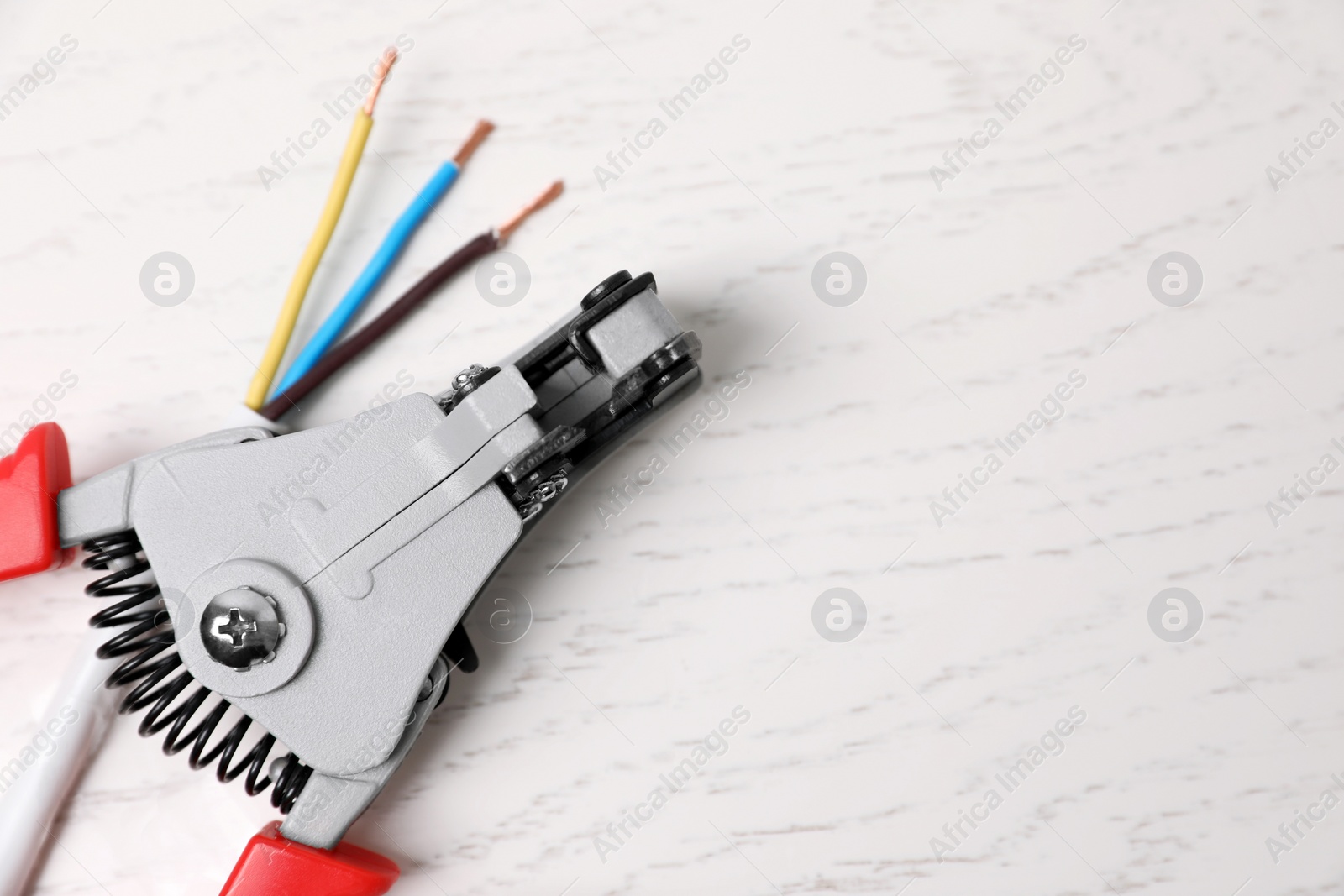 Photo of Professional cutters and wire on white wooden table, flat lay. Space for text