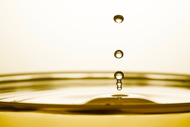 Image of Splash of golden oily liquid with drops on white background, closeup