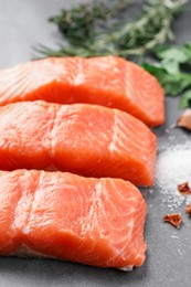 Photo of Fresh salmon with salt on grey table, closeup