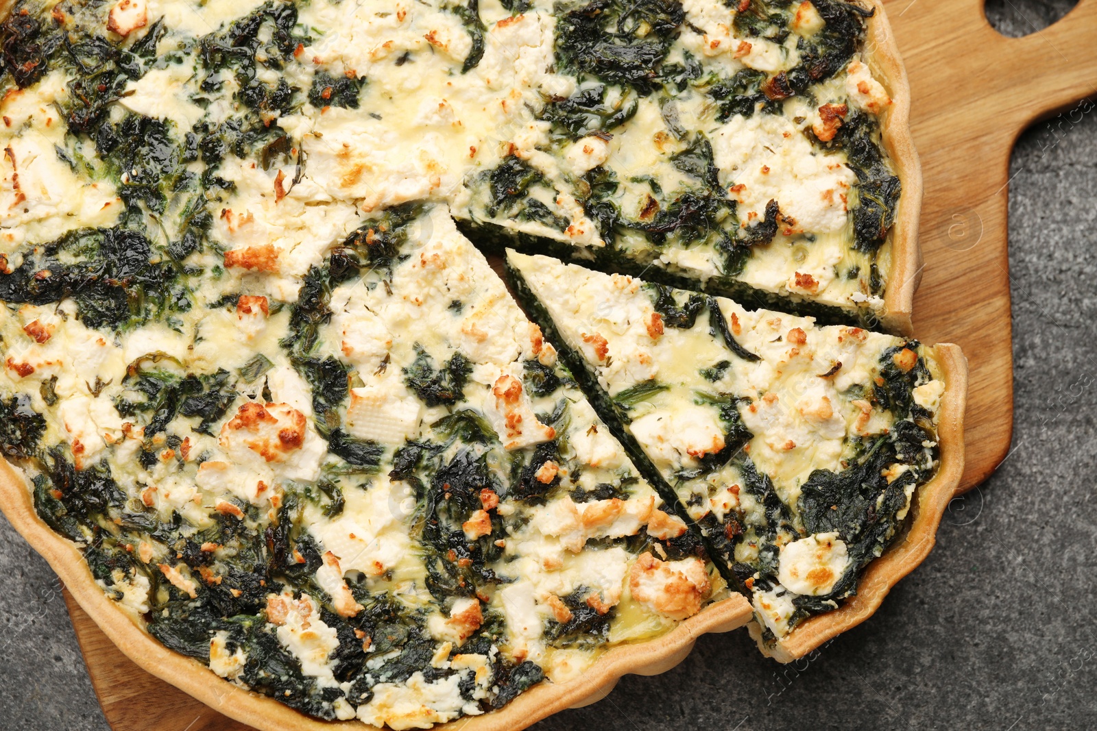 Photo of Delicious homemade spinach quiche on gray table, top view