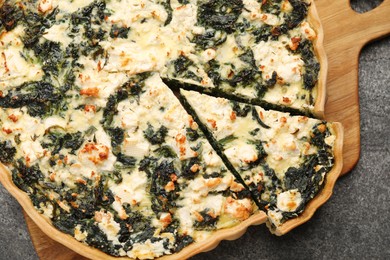 Delicious homemade spinach quiche on gray table, top view