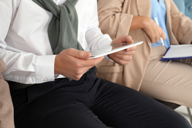 Photo of Man with tablet waiting for job interview in office, closeup