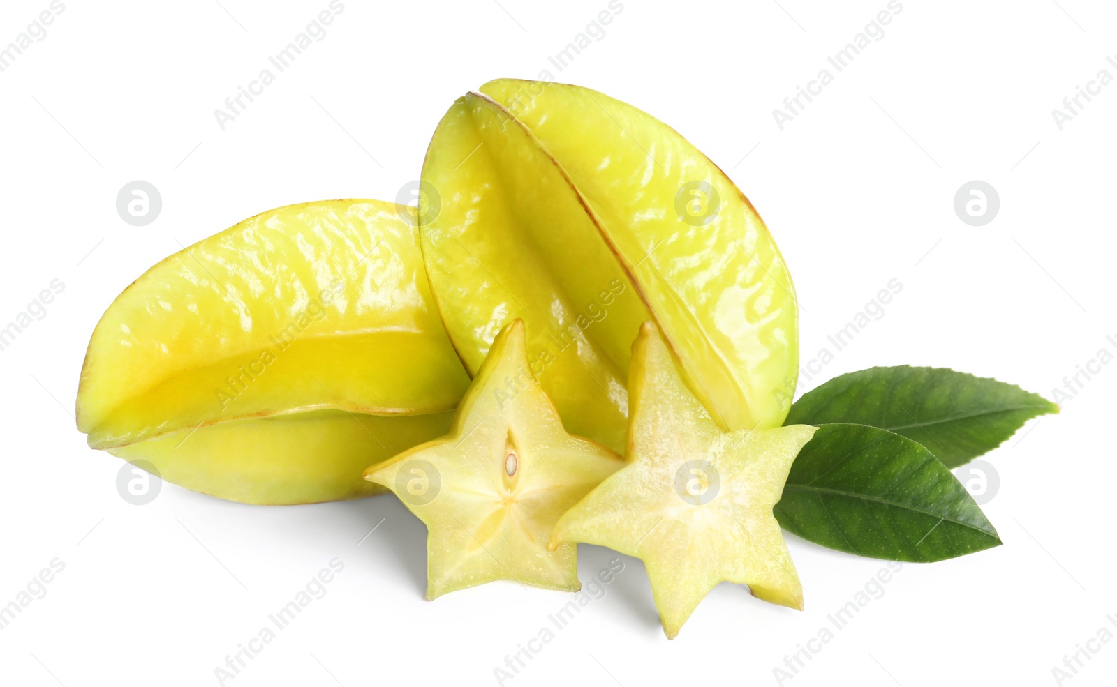 Photo of Cut and whole carambolas with green leaves on white background