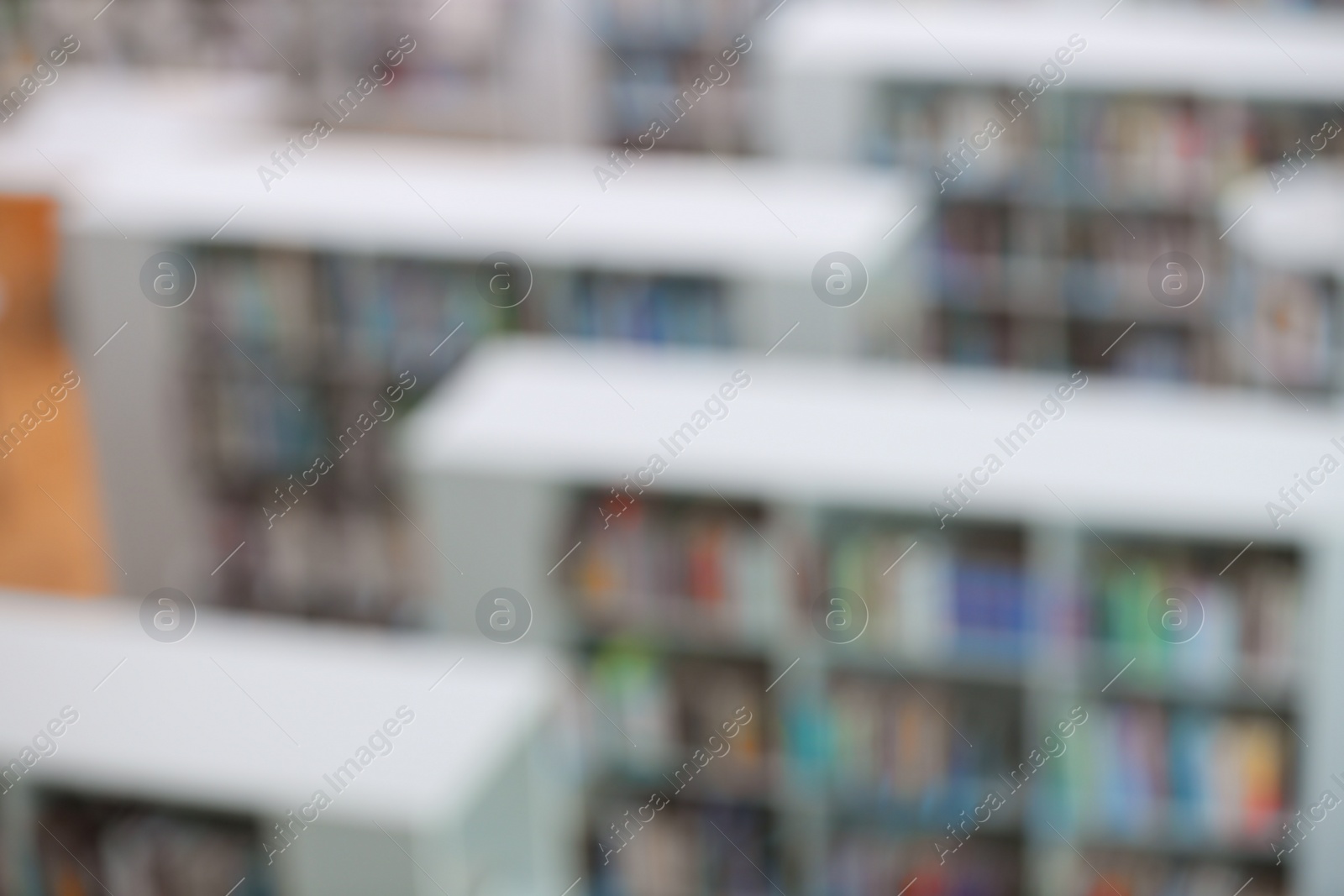 Photo of Blurred view of shelving units with books in library