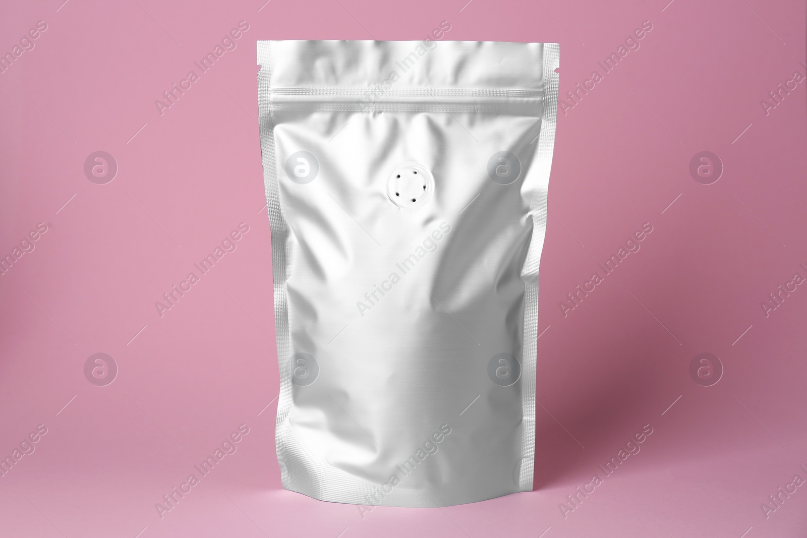 Photo of One blank foil package on pink background