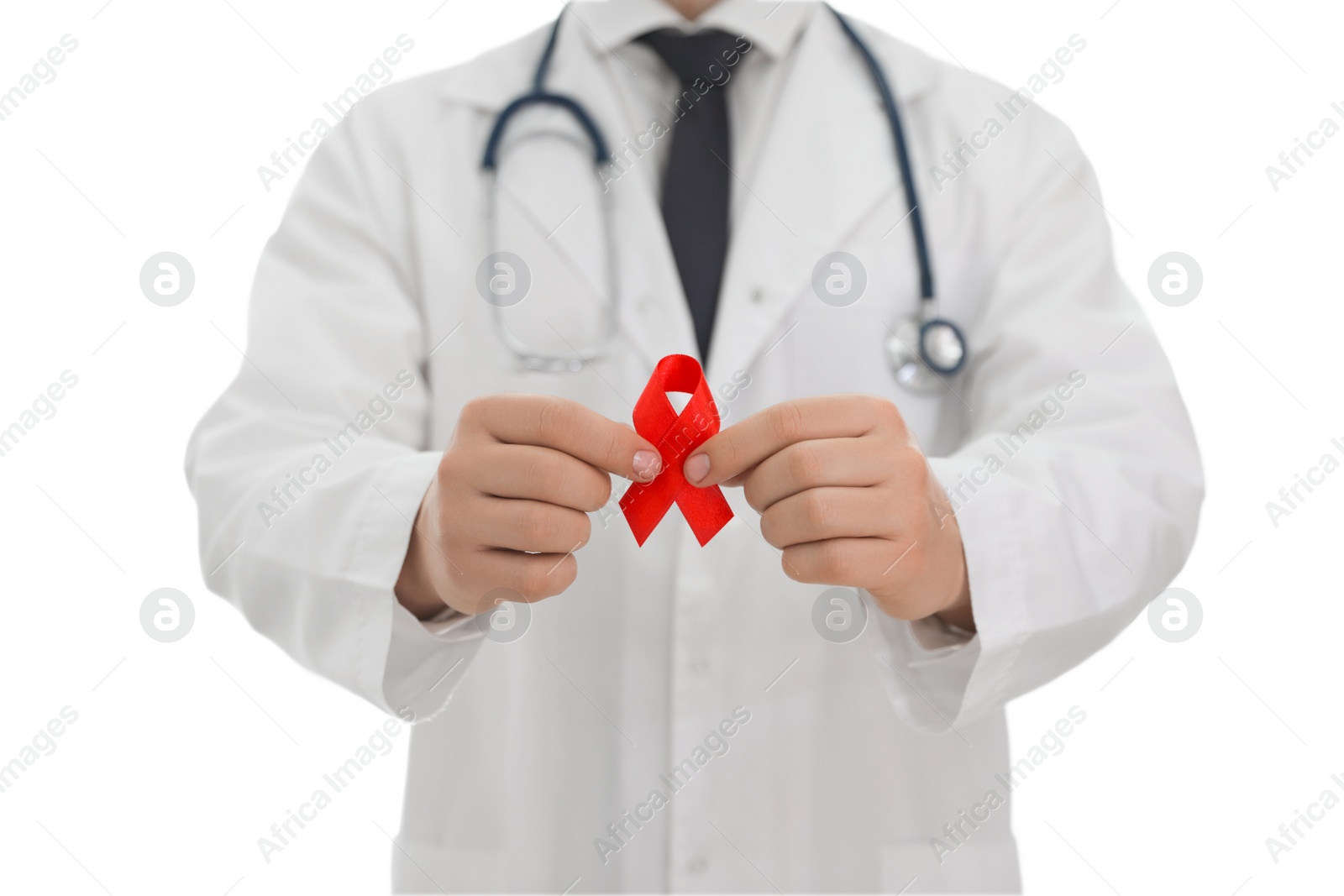 Photo of Doctor holding red ribbon on blurred background, closeup. AIDS awareness month