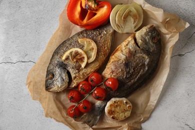 Photo of Delicious dorado fish with vegetables served on light grey table, top view