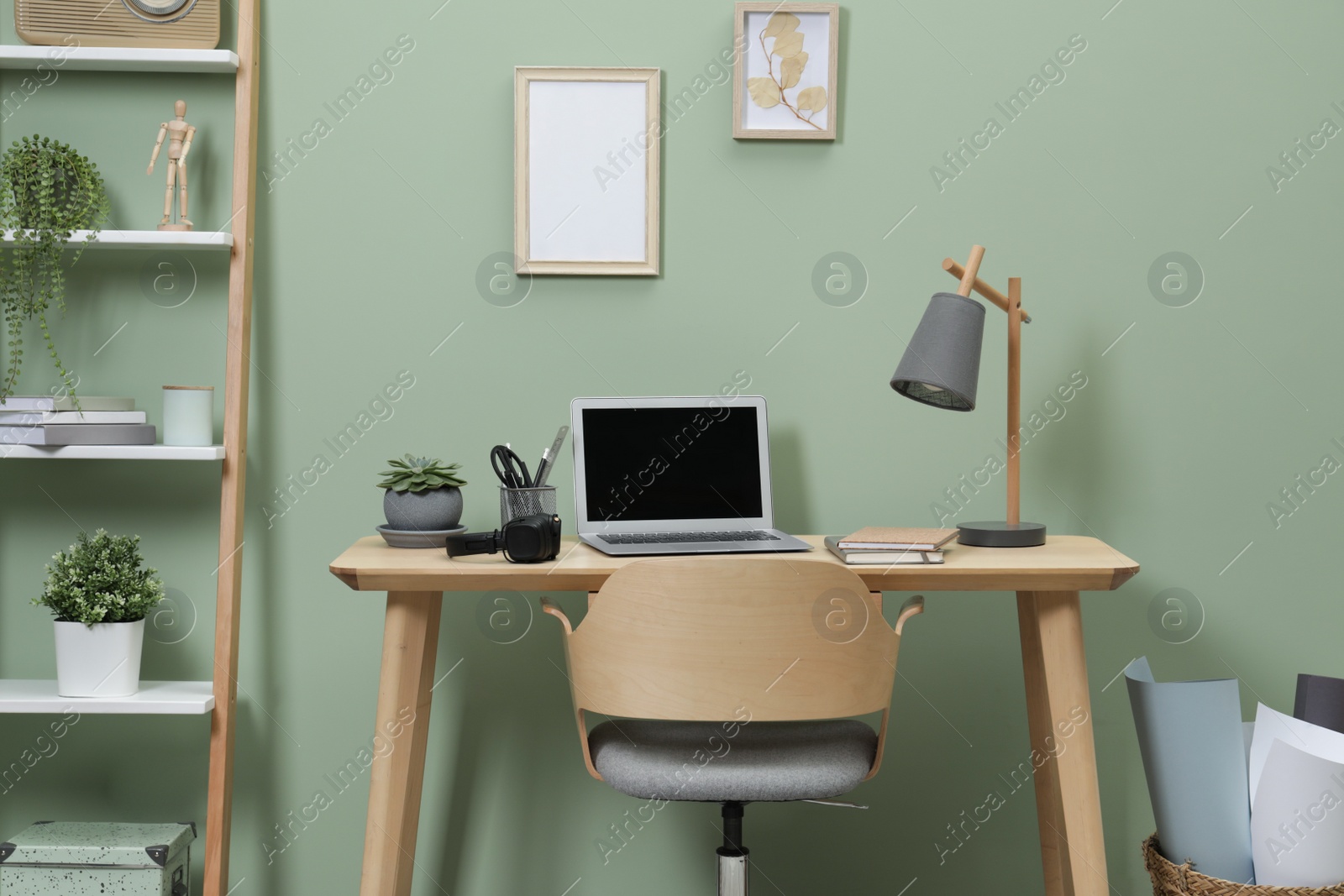 Photo of Workplace with laptop, stationery on desk and chair in home office