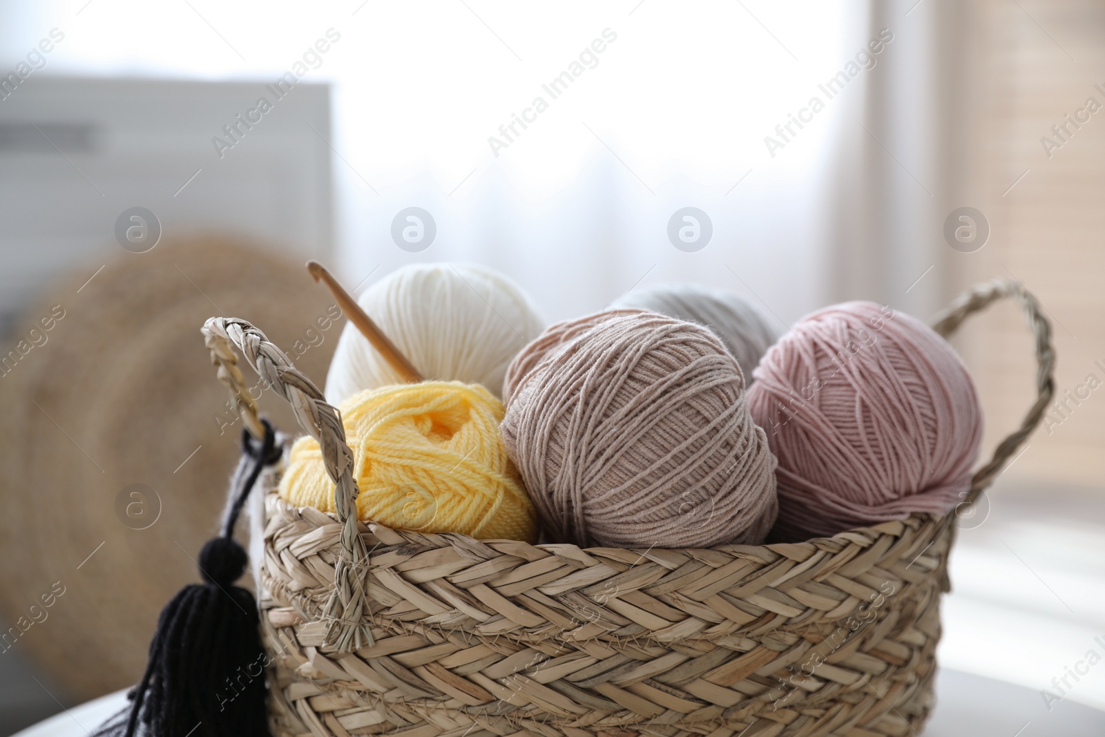 Photo of Wicker basket with clews and crochet indoors. Engaging in hobby