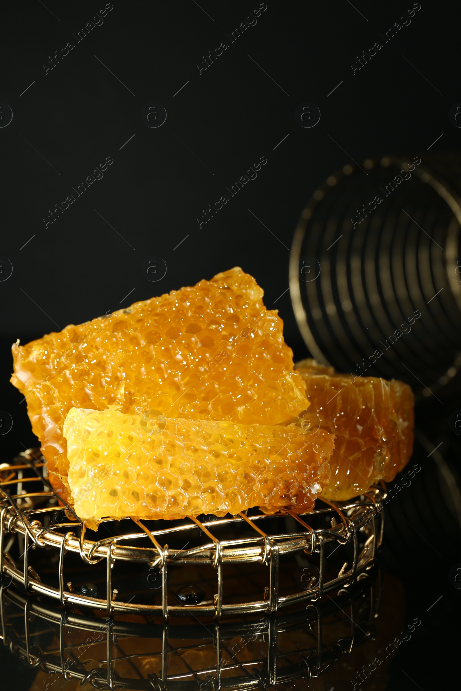 Photo of Natural honeycombs with tasty honey on black background