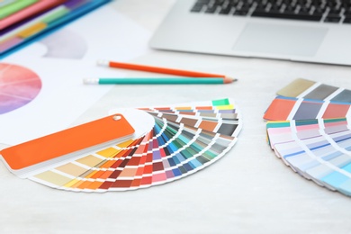 Photo of Paint color palette samples on table, closeup
