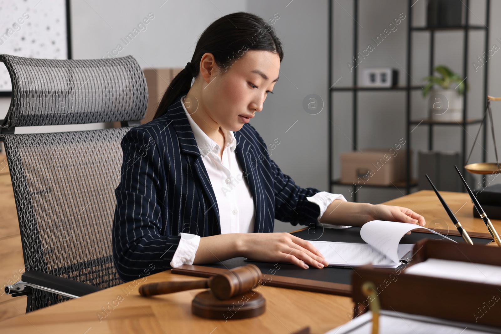 Photo of Notary reading document at table in office