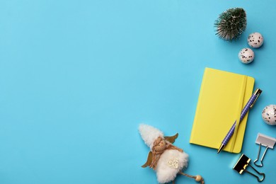 Photo of Yellow planner and Christmas decor on light blue background, flat lay. Space for text